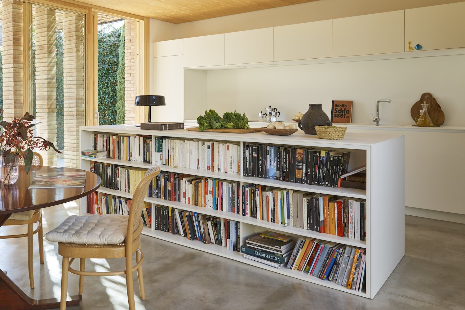 Cocina y comedor separados por una libreria. Un mueble bajo